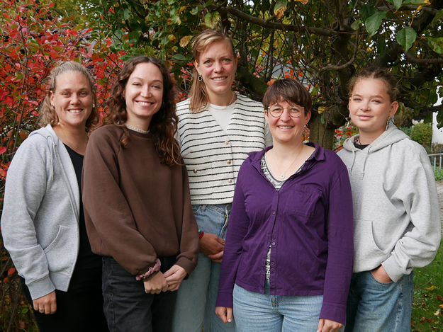 Foto des Teams der Geschftsstelle. 4 Personen mit Schild